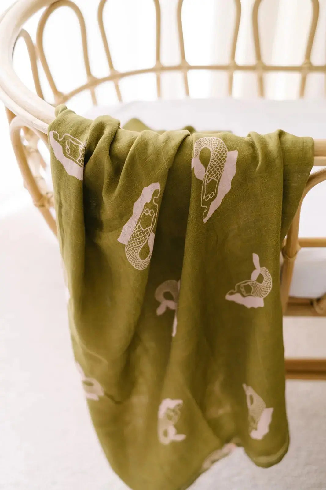 Mermaid muslin swaddle wrap hanging on cot close up